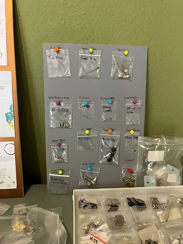 Craft supplies organized in labeled bags pinned to a board, with beads and findings visible.